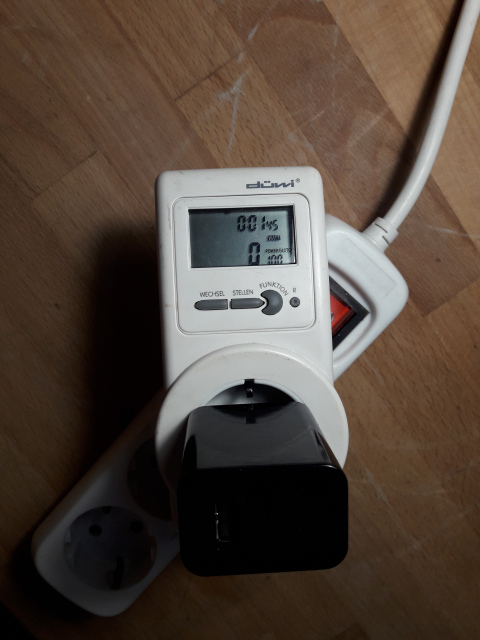 Ein Strommesgerät aus dem Baumarkt mit eingestecktem Netzteil zeigt 0W an.